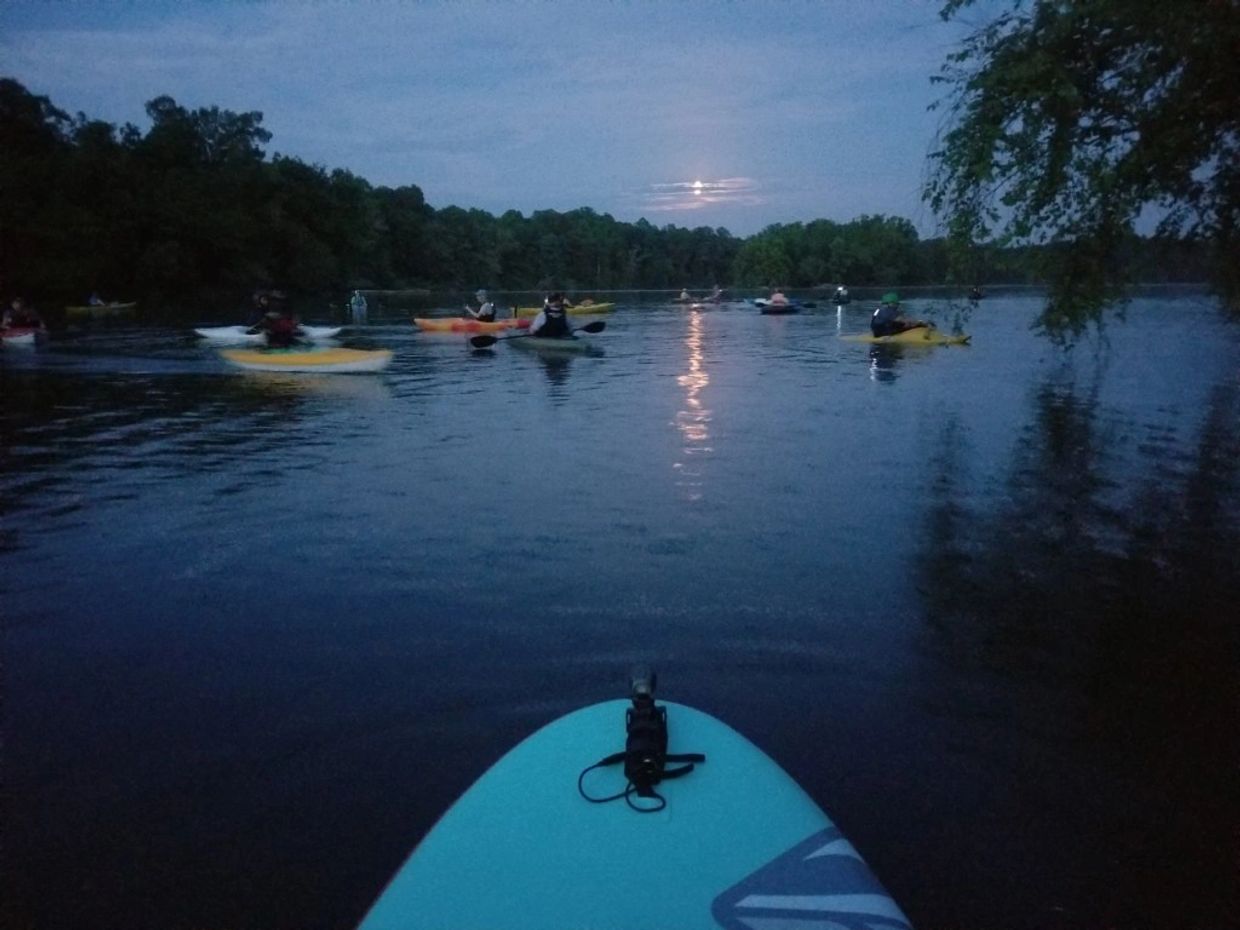 Paddlers on river under full moon
