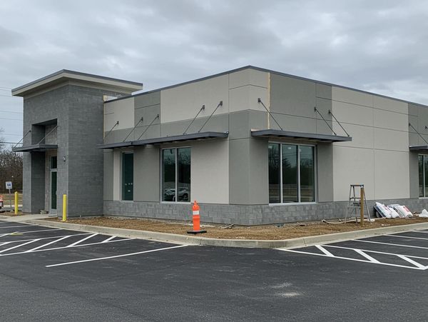 A contemporary style office building with awnings over windows.