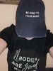 Female wearing a vintage look jean ball cap that says Be kind to your mind. 