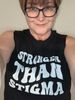 Female with glasses wearing a 'muscle' shirt that says Stronger than stigma. 