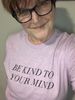 Female wearing a pink t-shirt that says Be kind to your mind. 