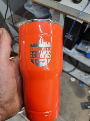 Orange tumbler with Baltimore Browns logo held in a hand.