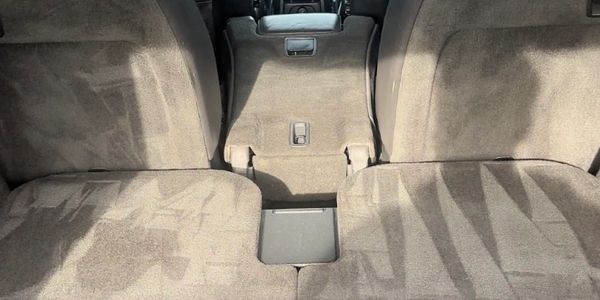 Folded car seats with a central armrest in a vehicle interior.