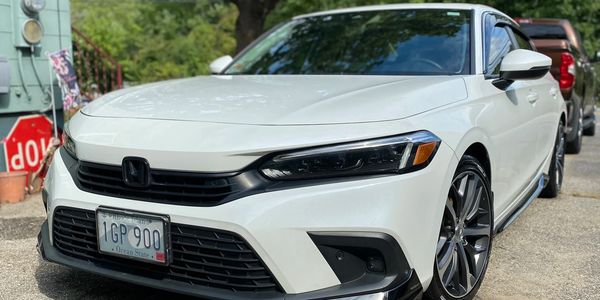 Sleek white Honda sedan parked outdoors with a clear sky reflection.