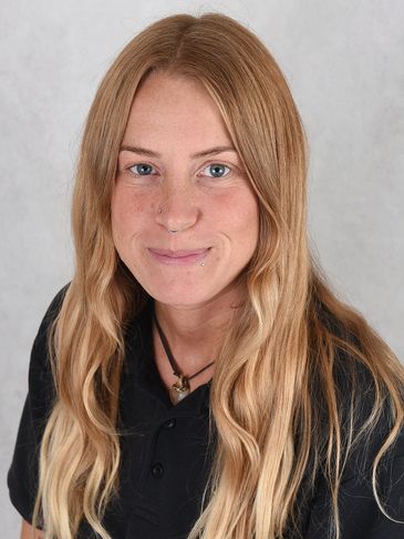 Young woman with long blonde hair wearing a black shirt and necklace.