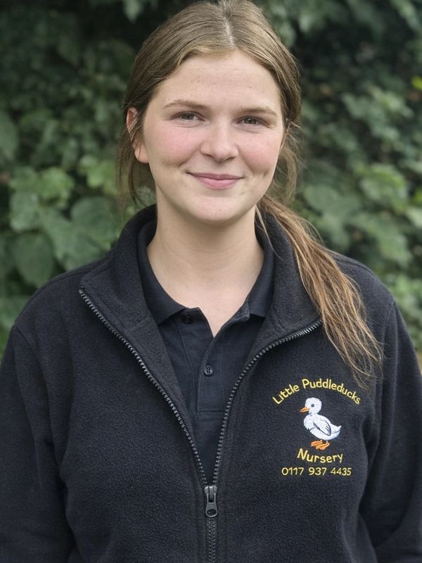 Young woman wearing a Little Puddleducks Nursery jacket and smiling.
