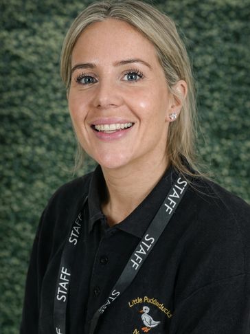 Smiling female staff member wearing a black shirt and lanyard.