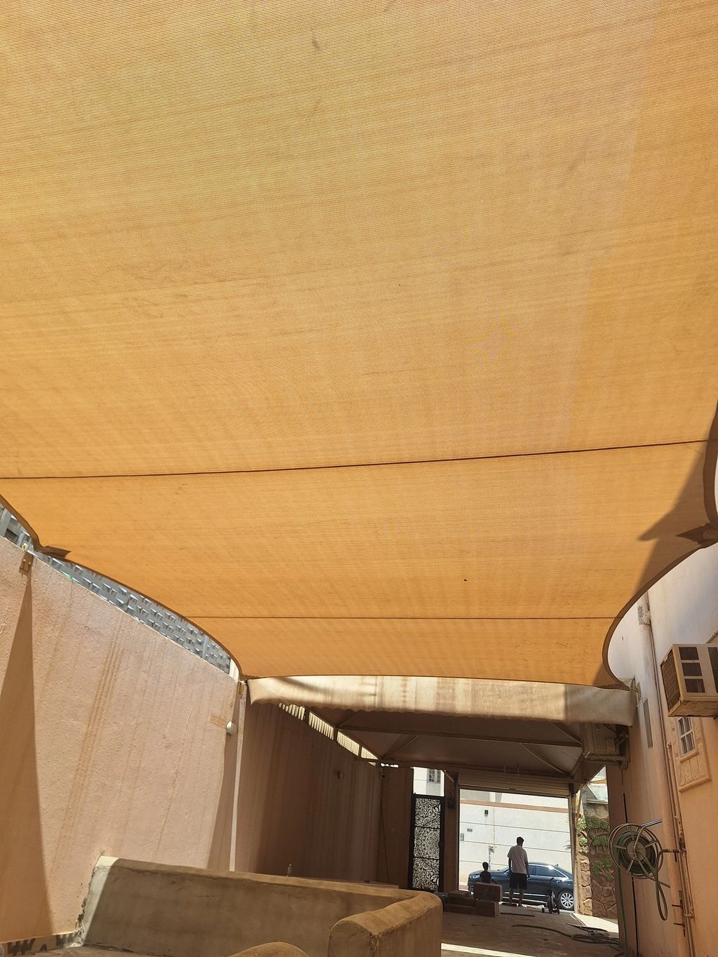 Outdoor covered passage with two people near entrance.