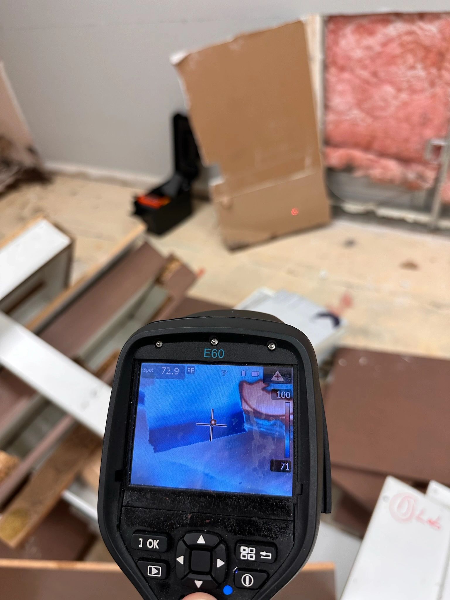 Thermal imaging tool measuring temperature in a construction area.
