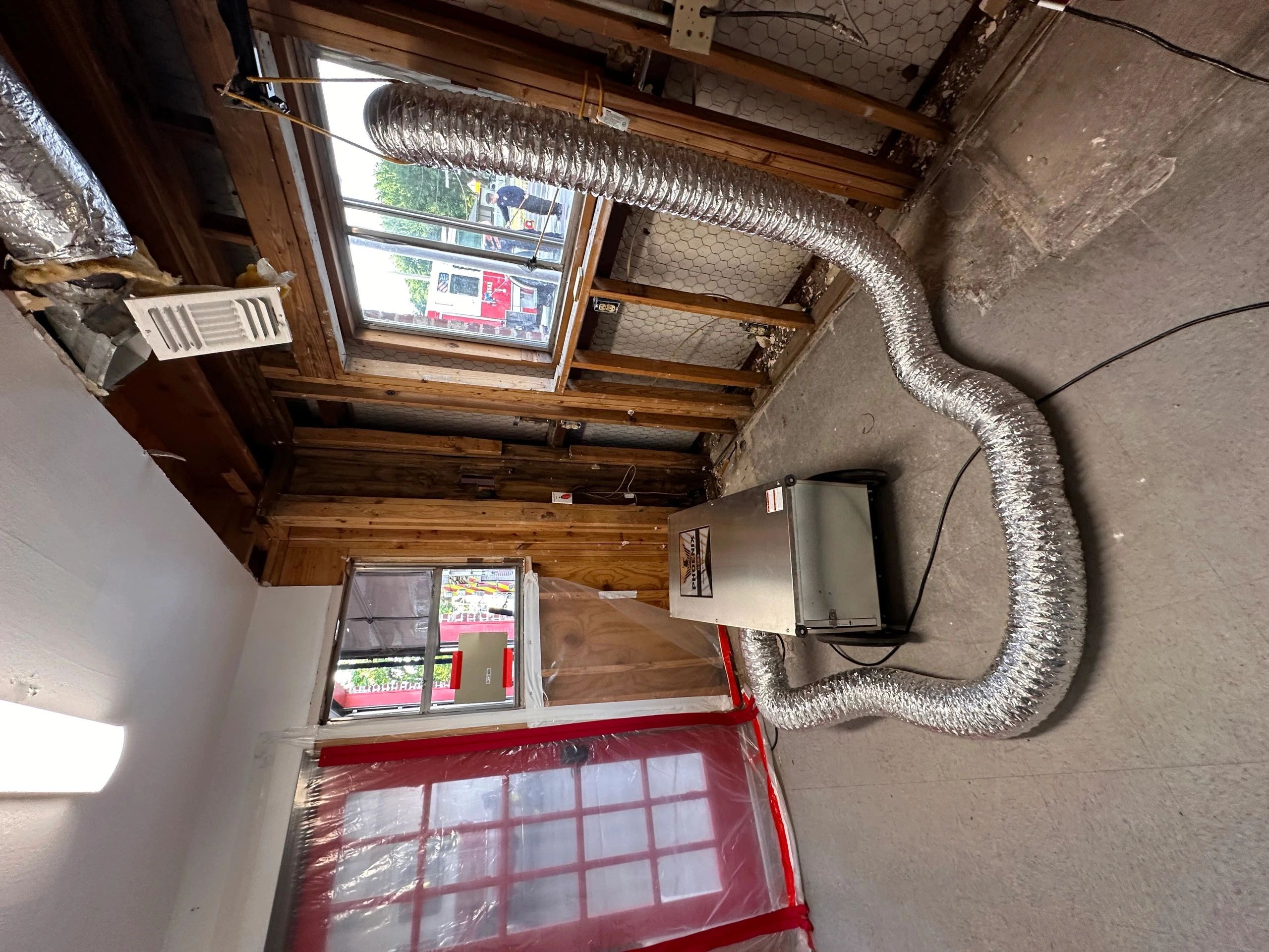 Air duct and dehumidifier in a partially stripped room.