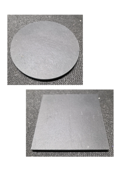 Two black matte surfaces, one circular and one square, on textured fabric.