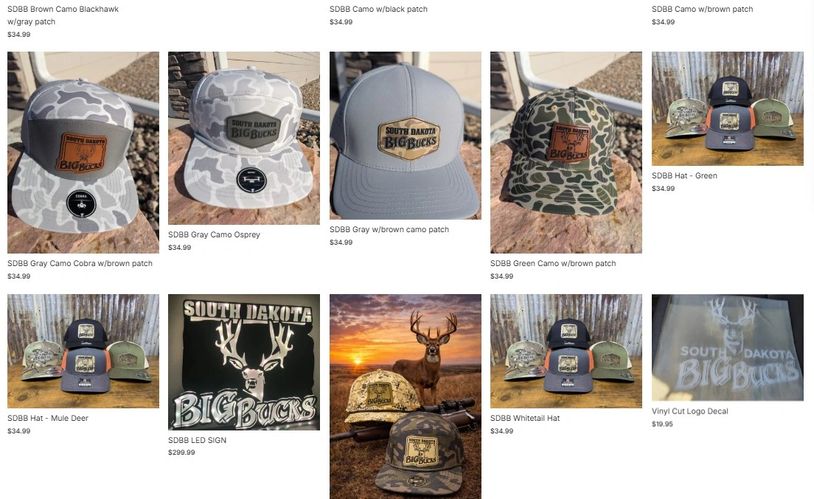Collection of South Dakota Big Bucks camo hats, LED sign, and decal.