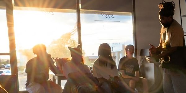 Group of people sitting and chatting in a sunlit room.