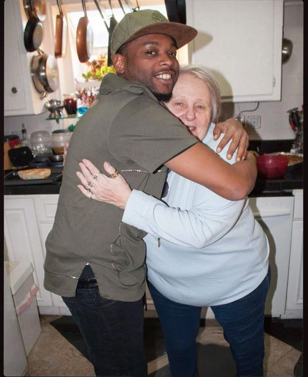 A son hugs his mother. 