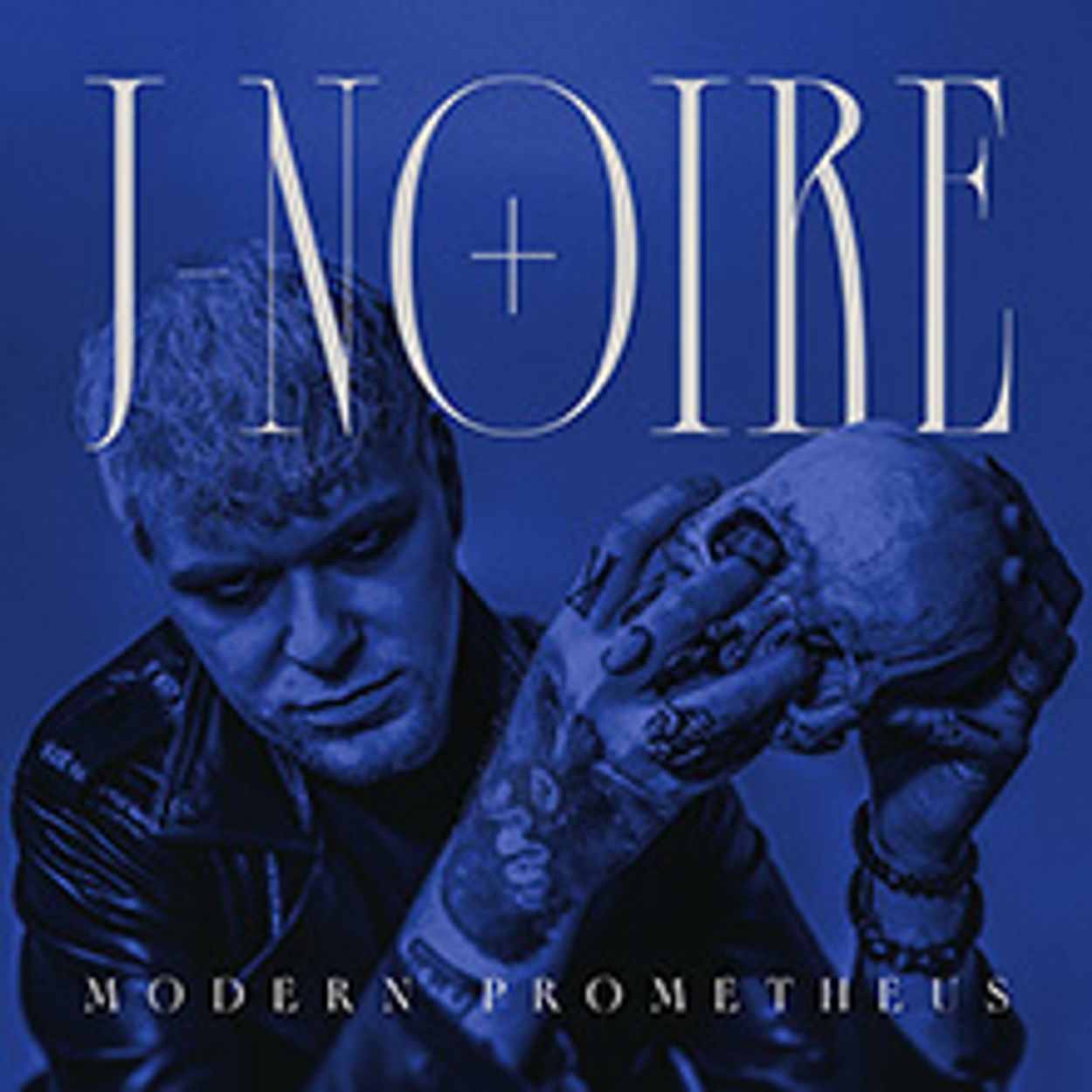 Man holding a skull with the title "JNOIRE Modern Prometheus."