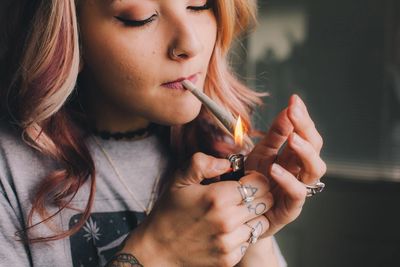 Super hot stoner girl smoking a joint of cannabis.