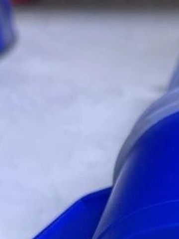 Close-up of a blue plastic container on a light surface.