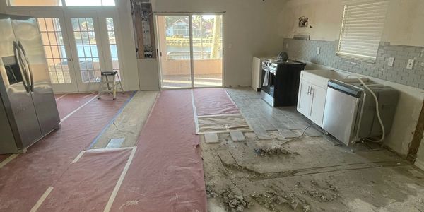 Kitchen under renovation with exposed flooring and appliances.