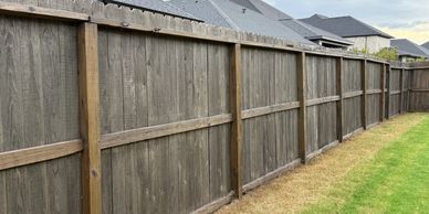 A long stained cedar fence separates improves the look of your backyard space