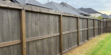 A long stained cedar fence separates improves the look of your backyard space