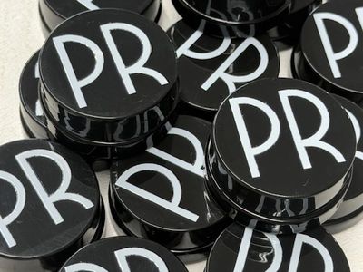 Black circular containers with white 'PR' letters stacked together.