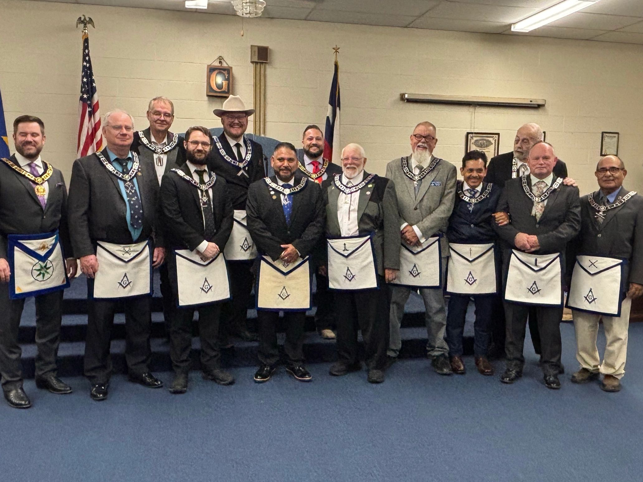 Group of men in formal attire with Masonic aprons and collars.