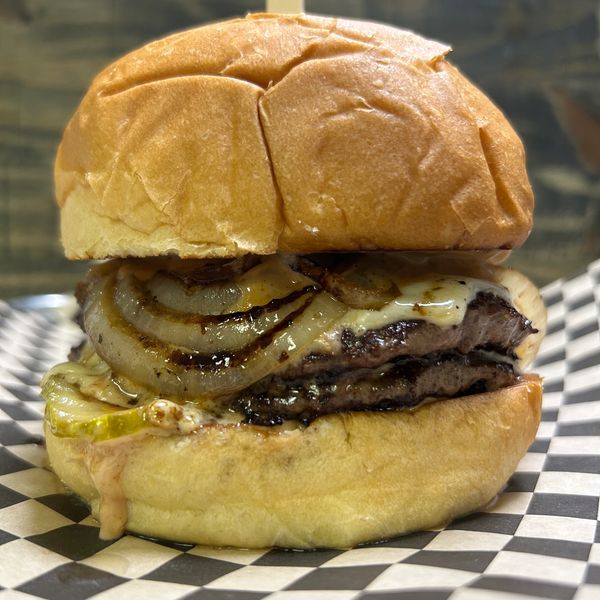 Juicy cheeseburger with grilled onions on a soft bun.