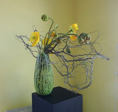 Bare twisted willow inside and outside glass vase with scribbly green detail, large yellow poppies 