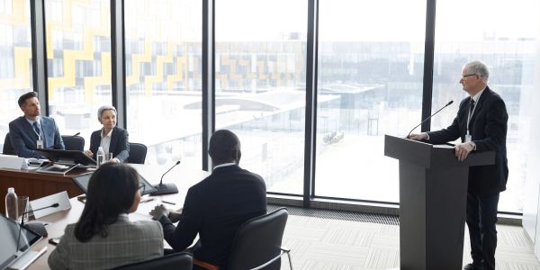 Business meeting with a speaker addressing attendees.