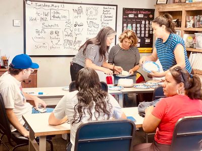 Adults participating in a classroom arts and crafts activity.