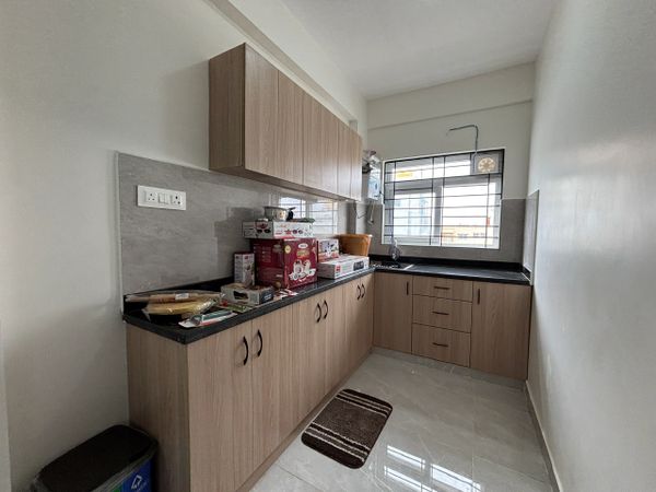Modern kitchen with wooden cabinets, black countertops, and boxed kitchen appliances on the counter.