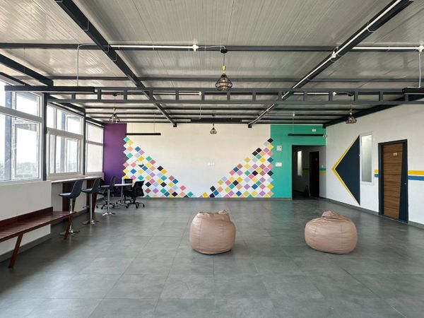 Modern open office space with colorful wall art and bean bags.