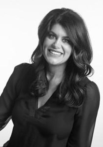 Smiling woman with long hair in a black blouse against white background.