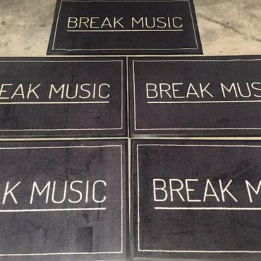 Multiple black mats with the text 'BREAK MUSIC' in white.
