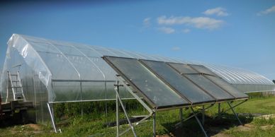 Solar hot water/glycol panels heat an underground tank to warm a greenhouse all winter.