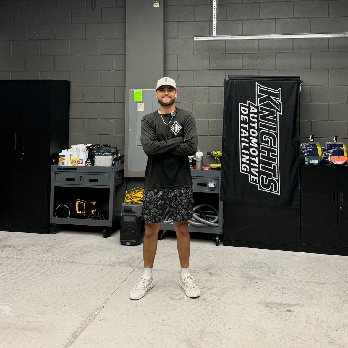 Man standing in an automotive detailing garage.