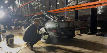Person working on a car wheel in a garage.