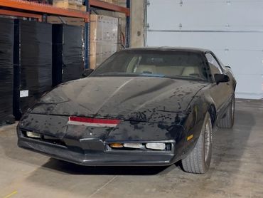 Black vintage sports car parked indoors.