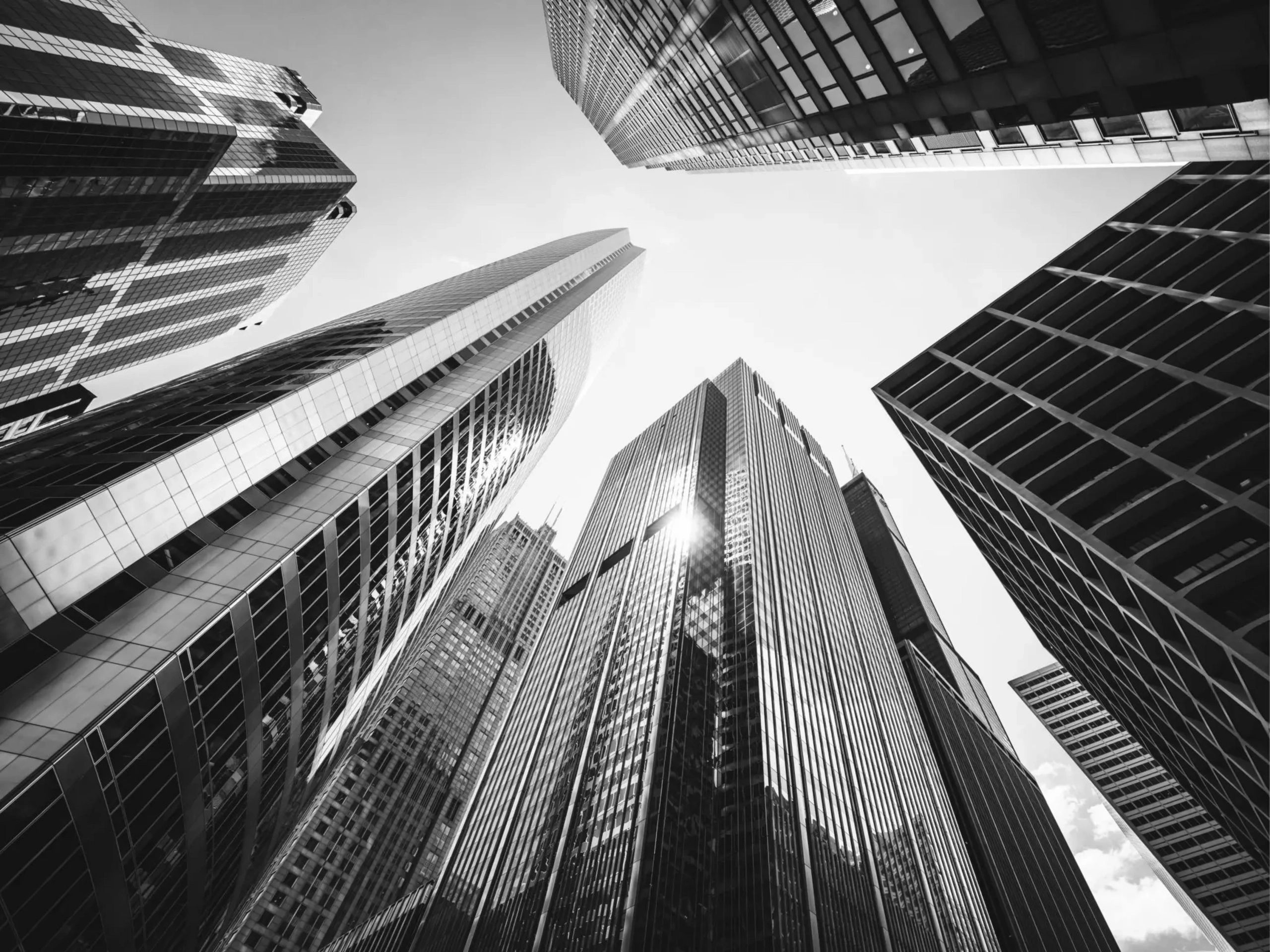 Black and white photo of towering skyscrapers from below.