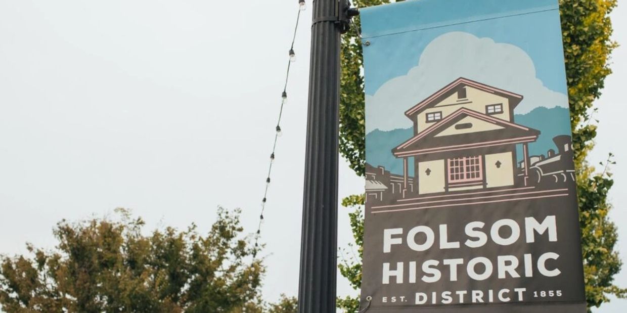 Banner sign for Folsom Historic District with an illustration of a house and train.