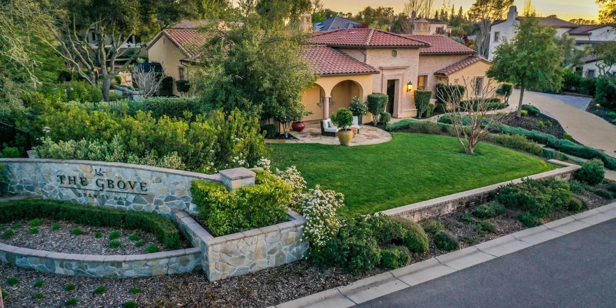Elegant house with lush green lawn and stone signage of The Grove Granite Bay.