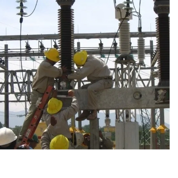 Workers wearing yellow helmets performing maintenance on electrical equipment.