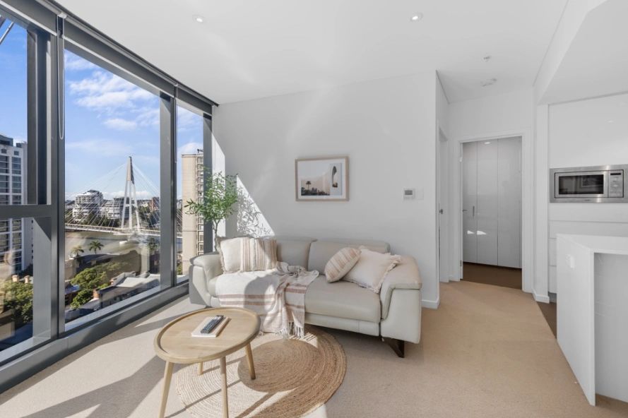 Bright living room with large windows offering a city and bridge view.