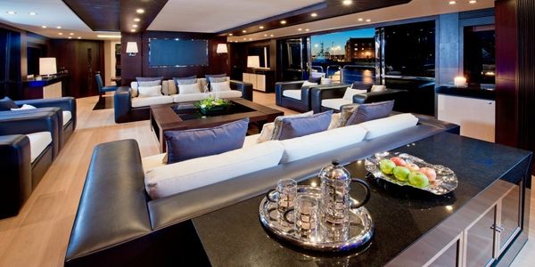Luxurious yacht interior with elegant seating and city night views.