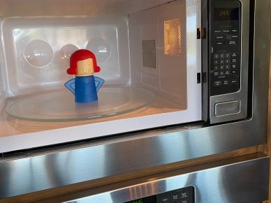 A microwave with a red-capped blue gadget inside.