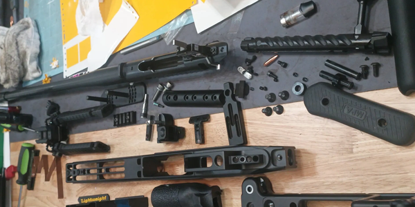 Disassembled firearm parts neatly arranged on a wooden surface.