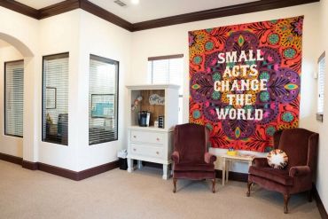 Cozy room with colorful inspirational wall art and two armchairs.