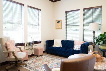 Cozy living room with blue sofa and natural light.