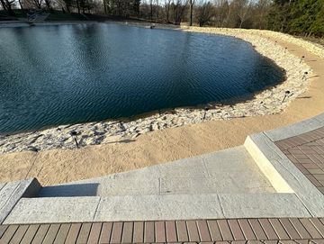 Stone steps leading to a calm body of water.