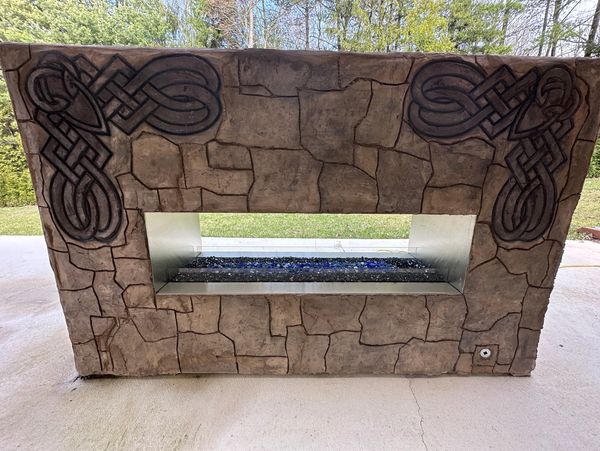 Outdoor stone fireplace with Celtic designs.